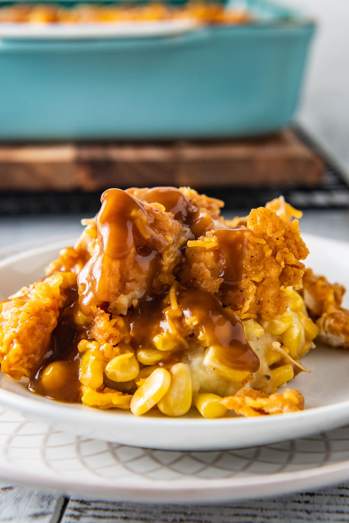 a plate with crispy chicken casserole made with mashed potatoes, corn, cheese, and gravy