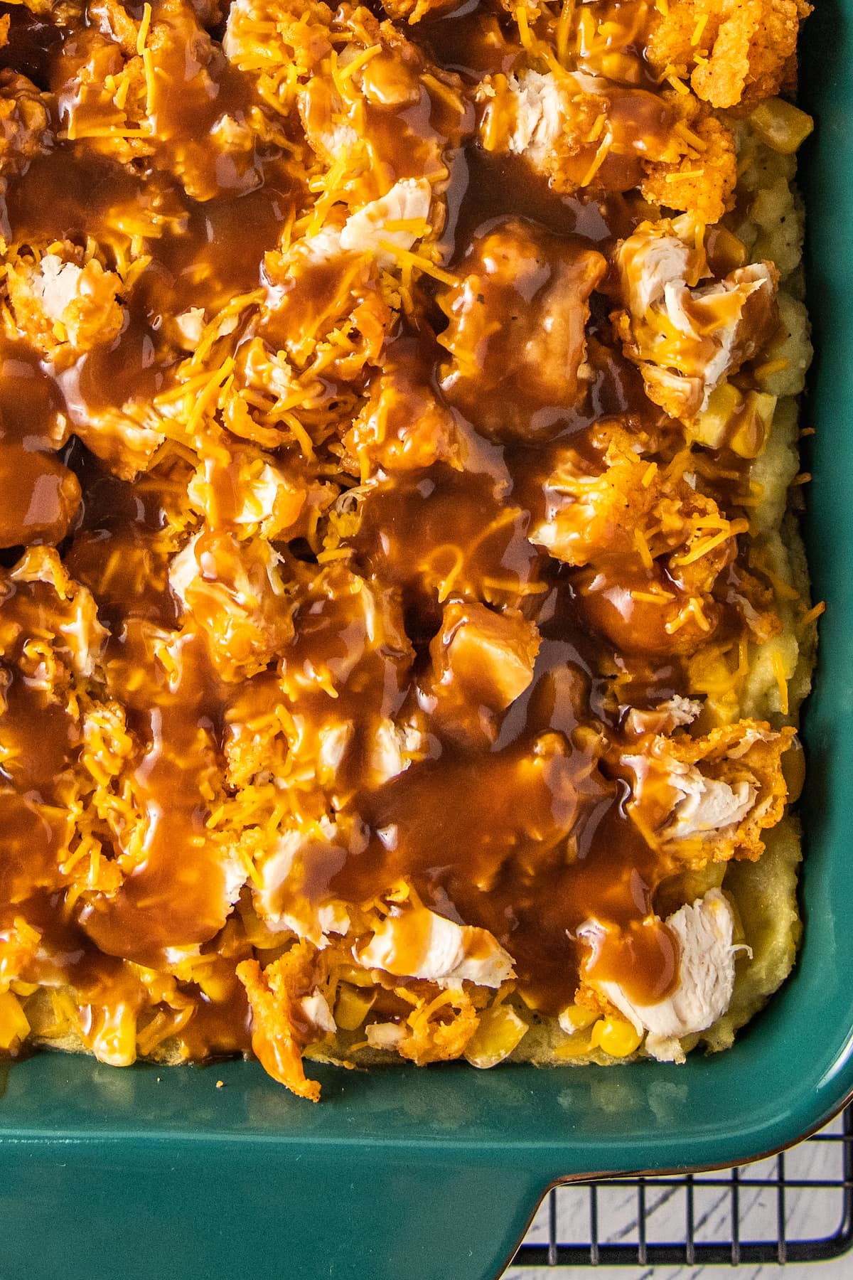 top view of a fried chicken and gravy casserole in a green baking dish