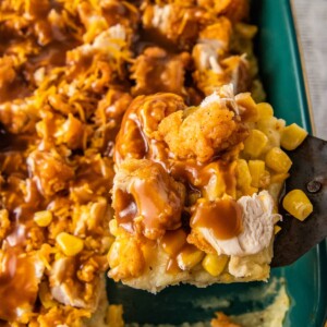 close up of a slice of fried chicken casserole with mashed potatoes, corn, cheese, and gravy