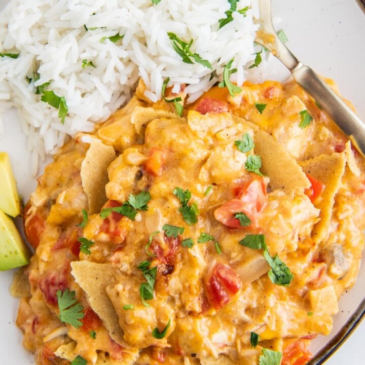 a plate with chicken and cheese casserole with sliced avocado and rice