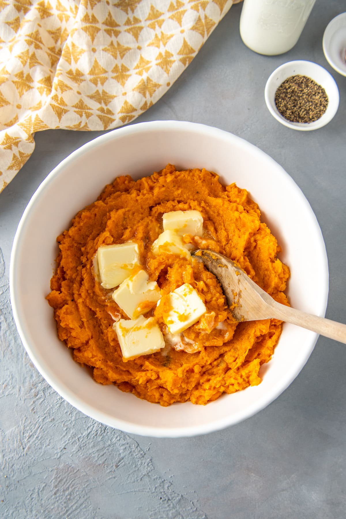 stirring butter into a bown of pureed sweet potatoes