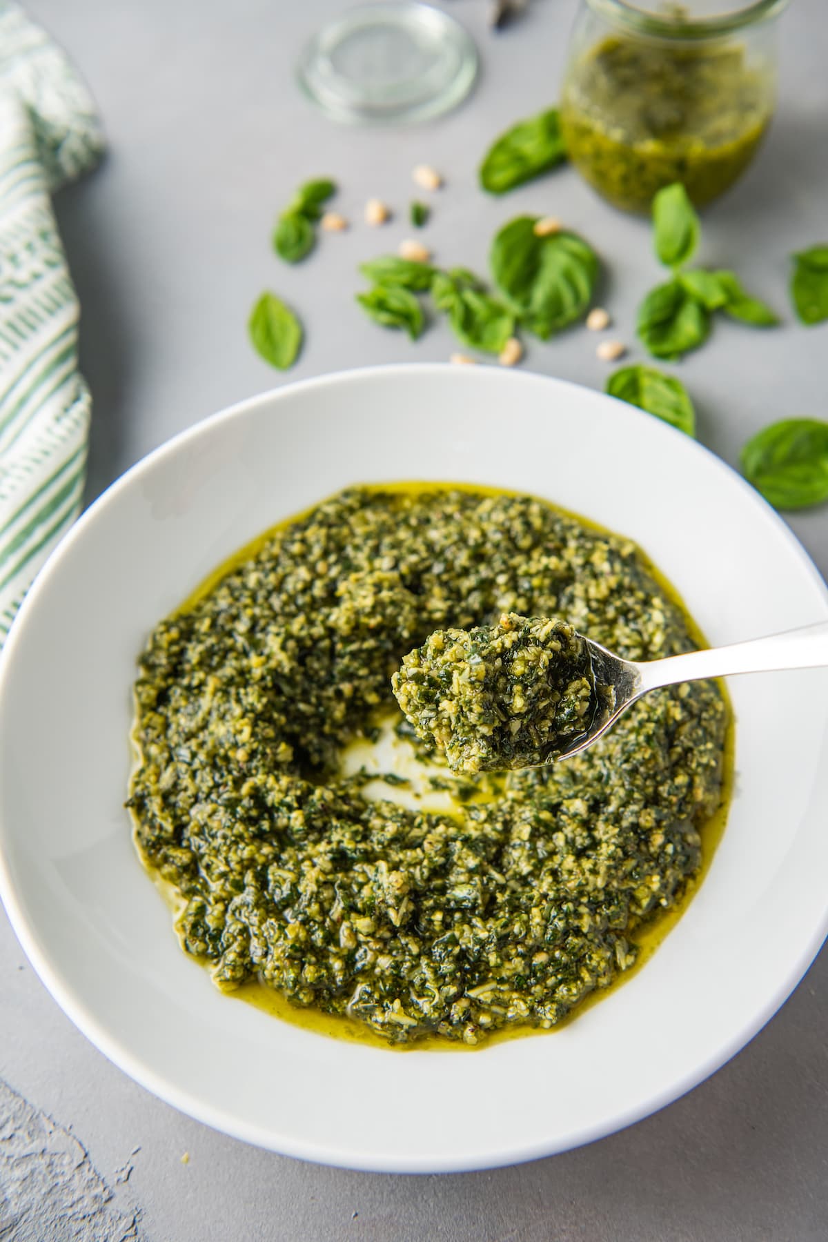 pesto in a white bowl with a metal spoon