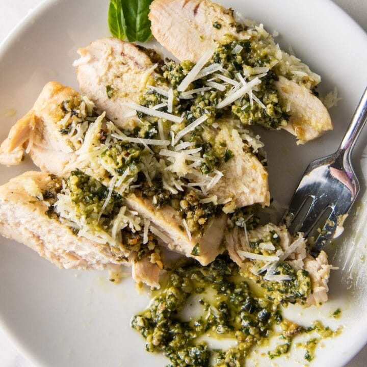 cut up cooked chicken with pesto on top