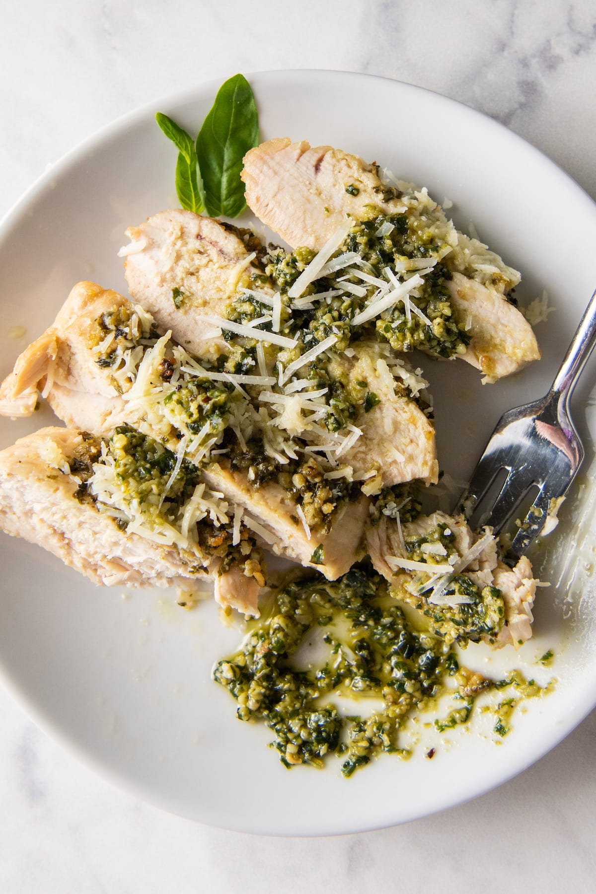 cut up cooked chicken with pesto on top