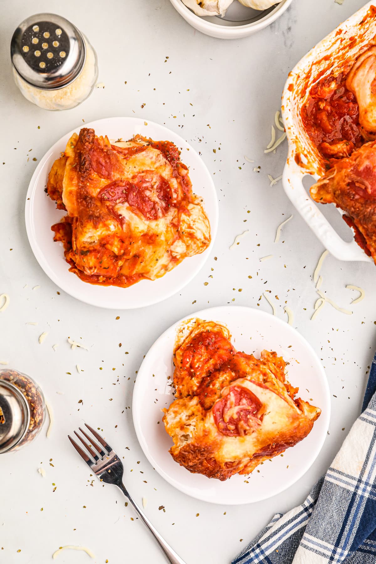 top view of two pieces of pizza cut out from pizza casserole on two seperate white plates