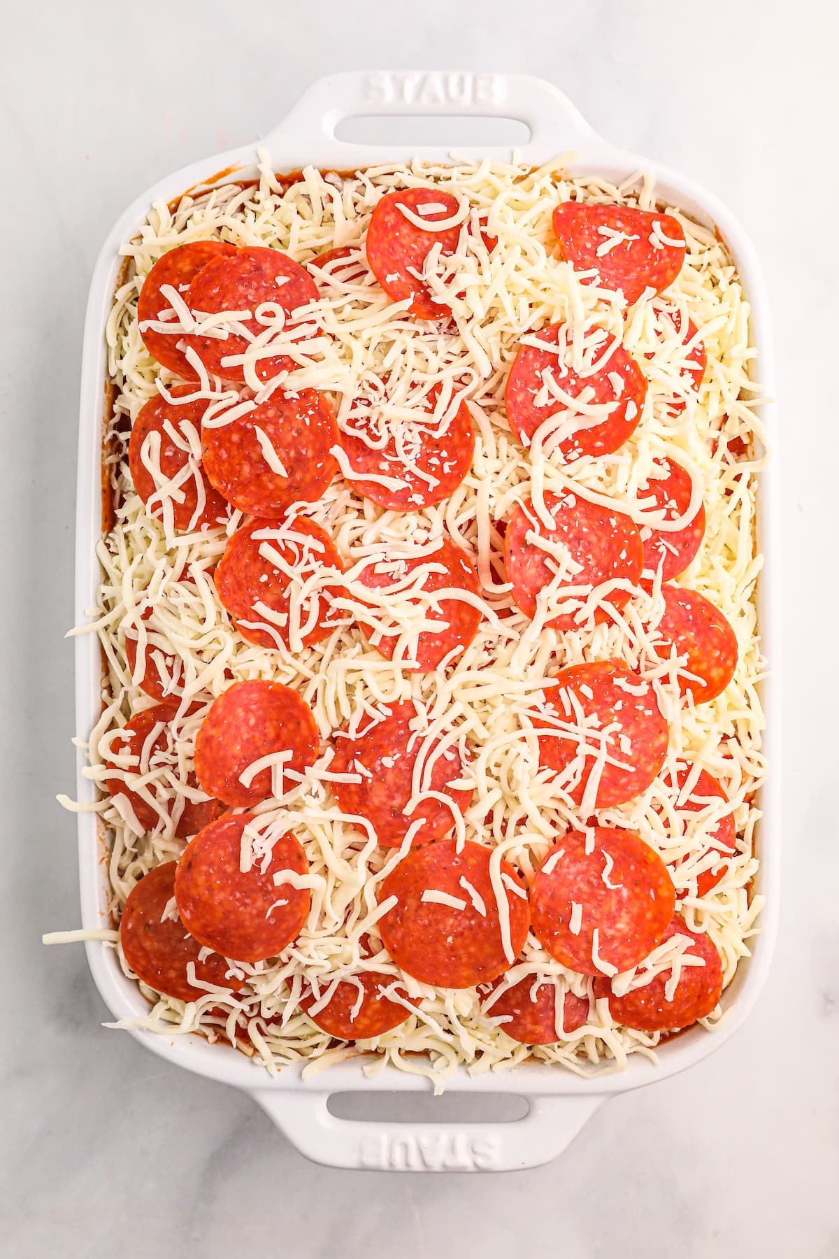 pizza casserole before it has been cooked, in a baking dish