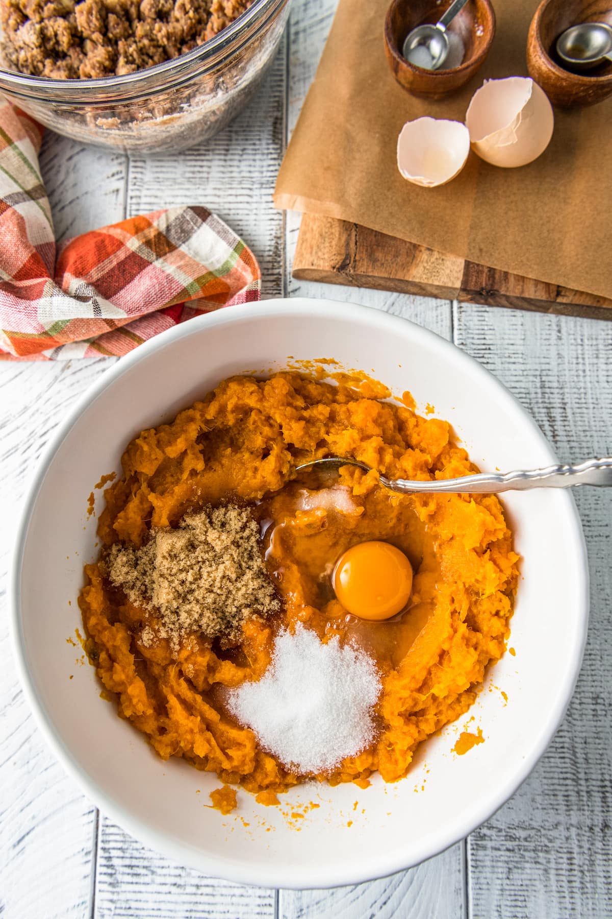 a mixing bowl with pureed sweet potatoes, egg, flour and brown sugar