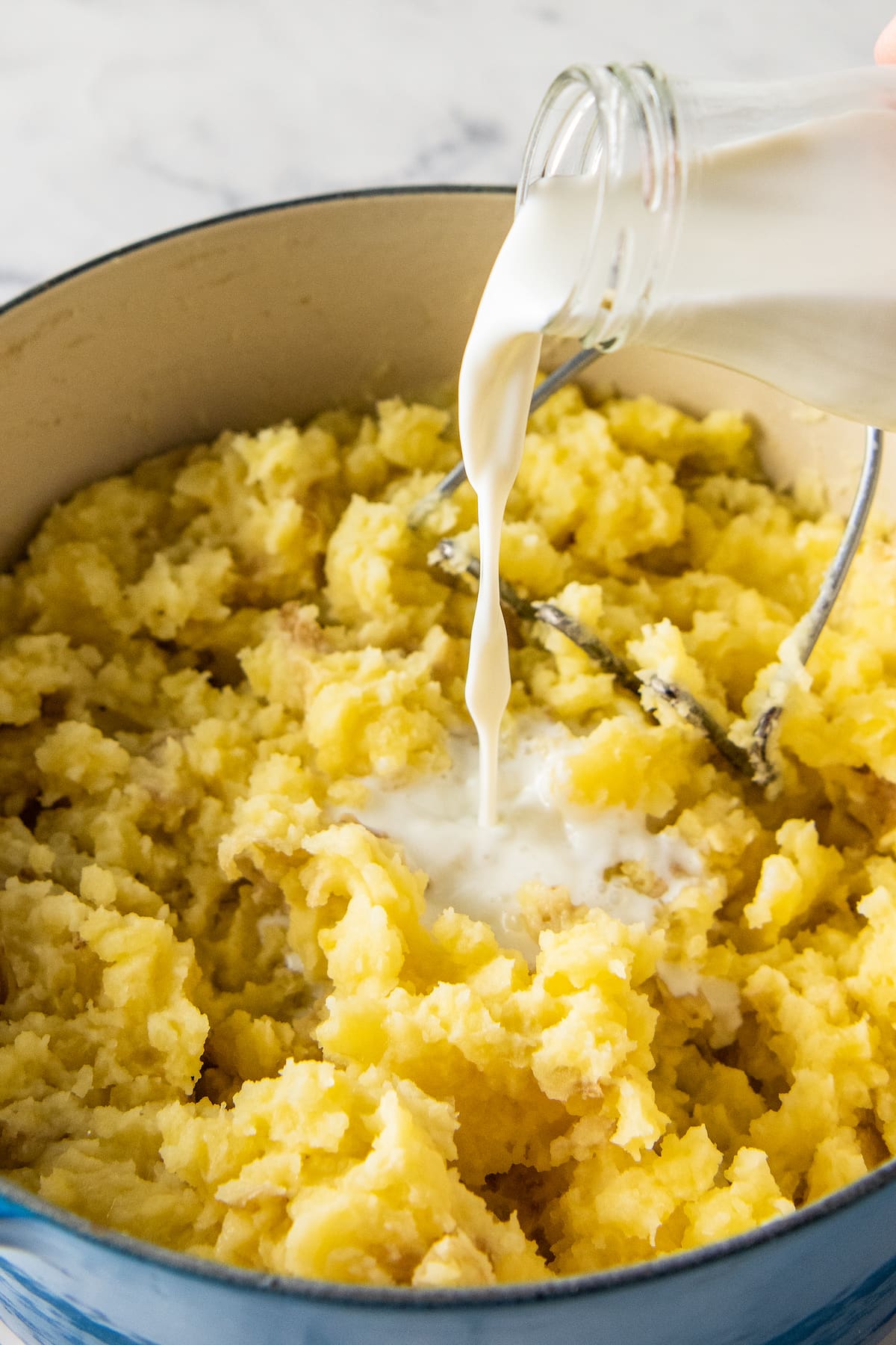 adding cream to mashed potatoes