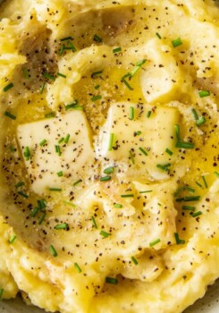 close up of mashed potatoes with butter, herbs, salt and pepper on top