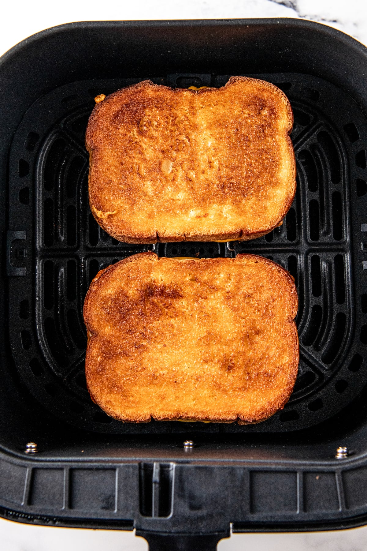 two toasted sandwiches in an air fryer