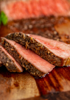 sliced medium-rare steak that's heavily seasoned