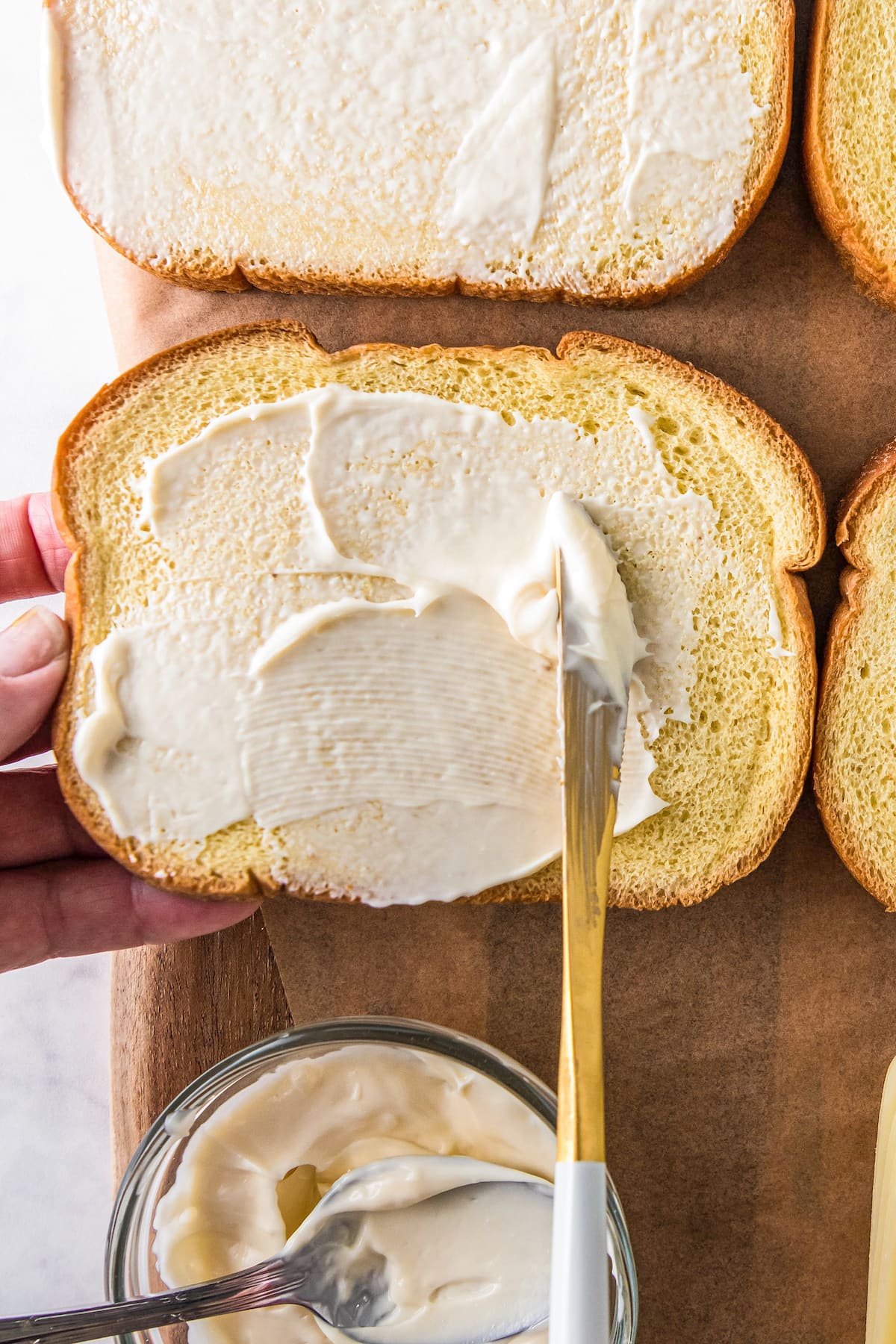 spreading of mayonnaise on a slice of bread