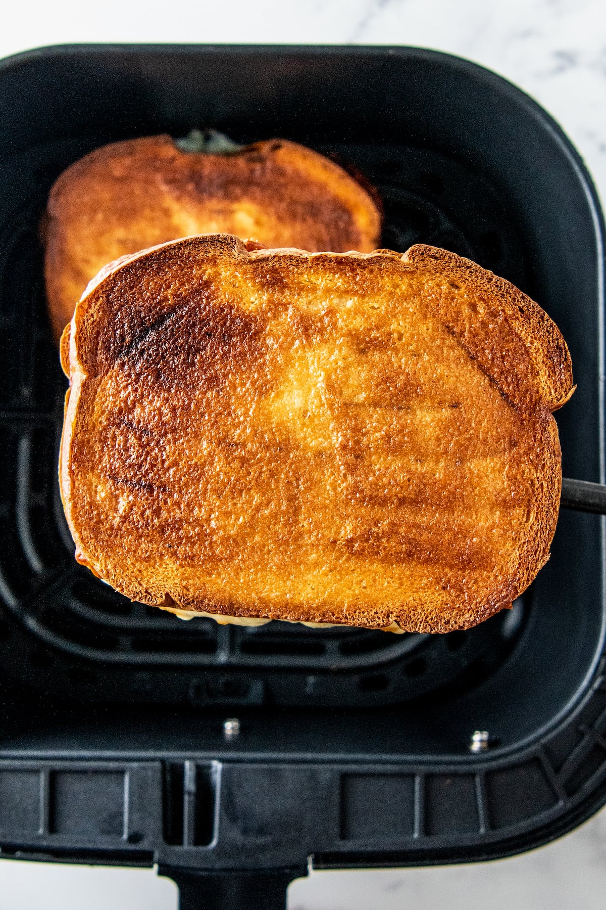 a grilled sandwich in an air fryer tray
