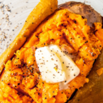 A baked sweet potato topped with butter, salt and pepper.