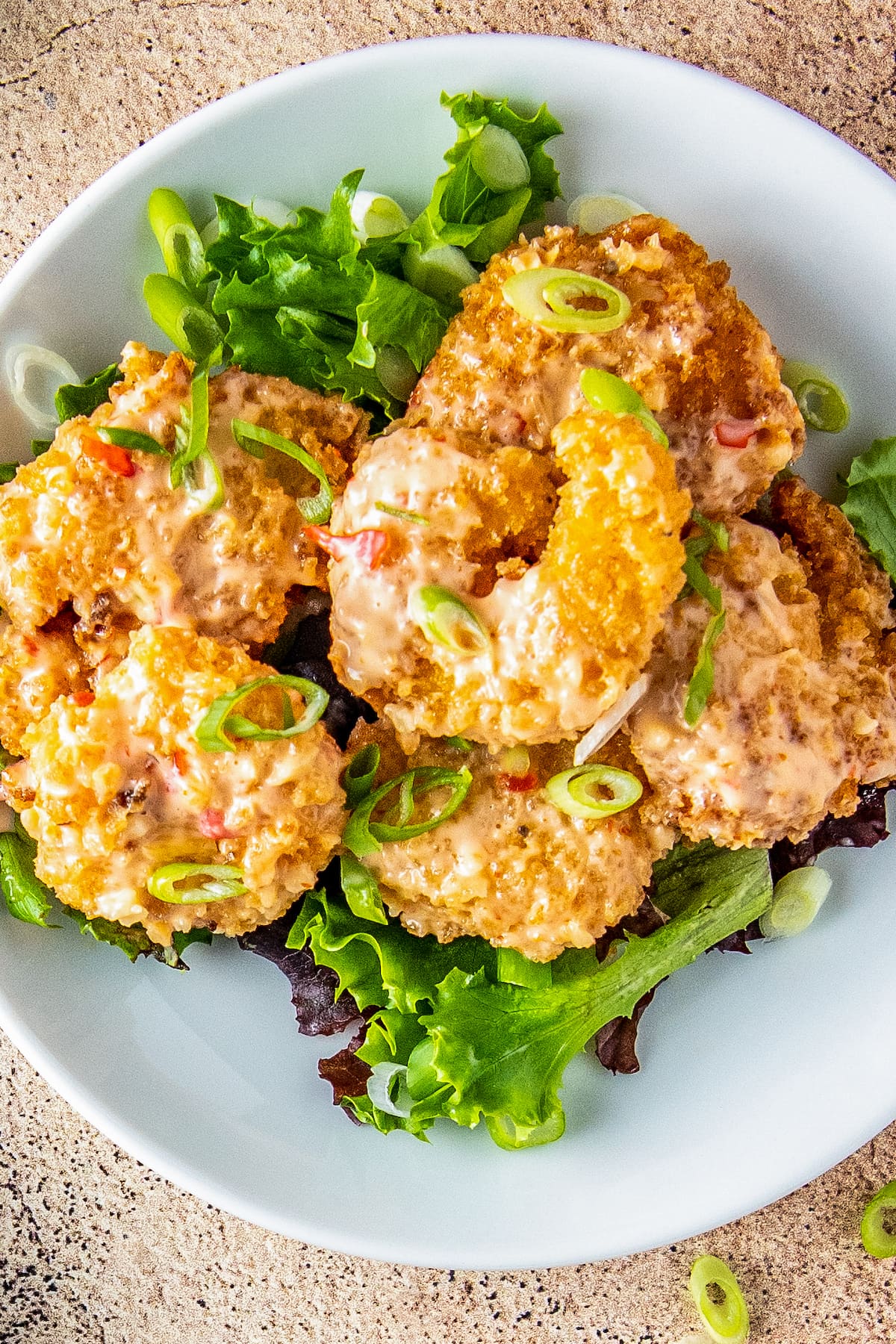 Fried bang bang shrimp with sauce on salad greens