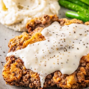 chicken fried steak with white gravy on top