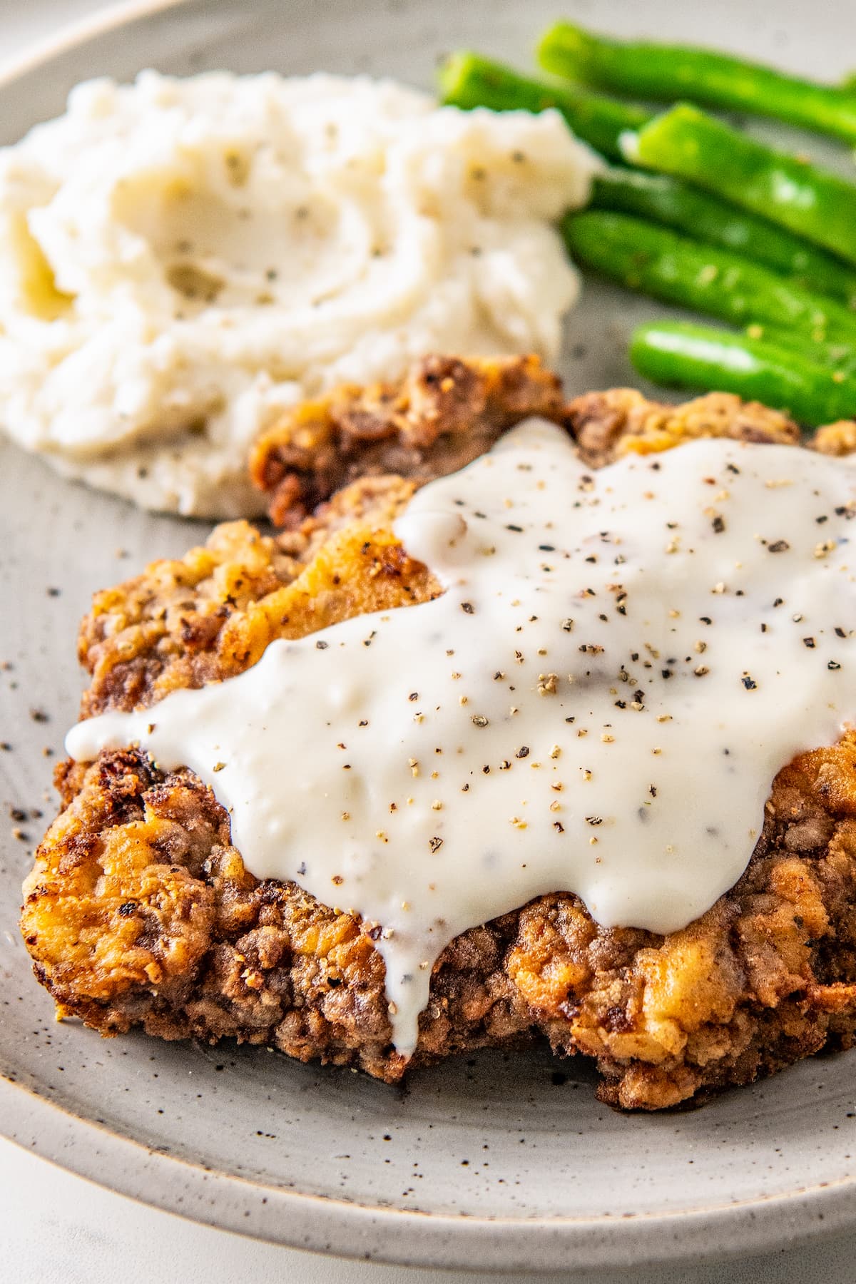 chicken fried steak with white gravy on top