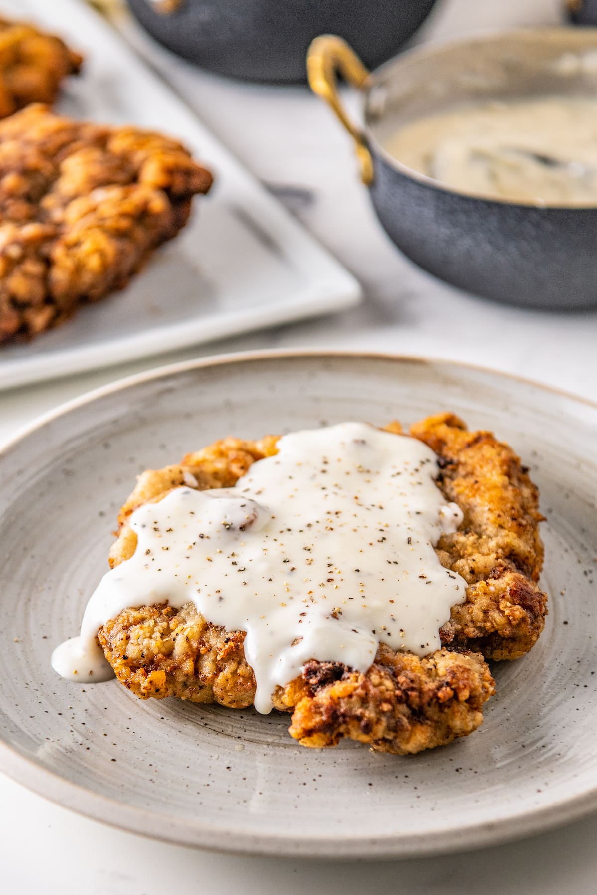 chicken fried steak with white gravy on top