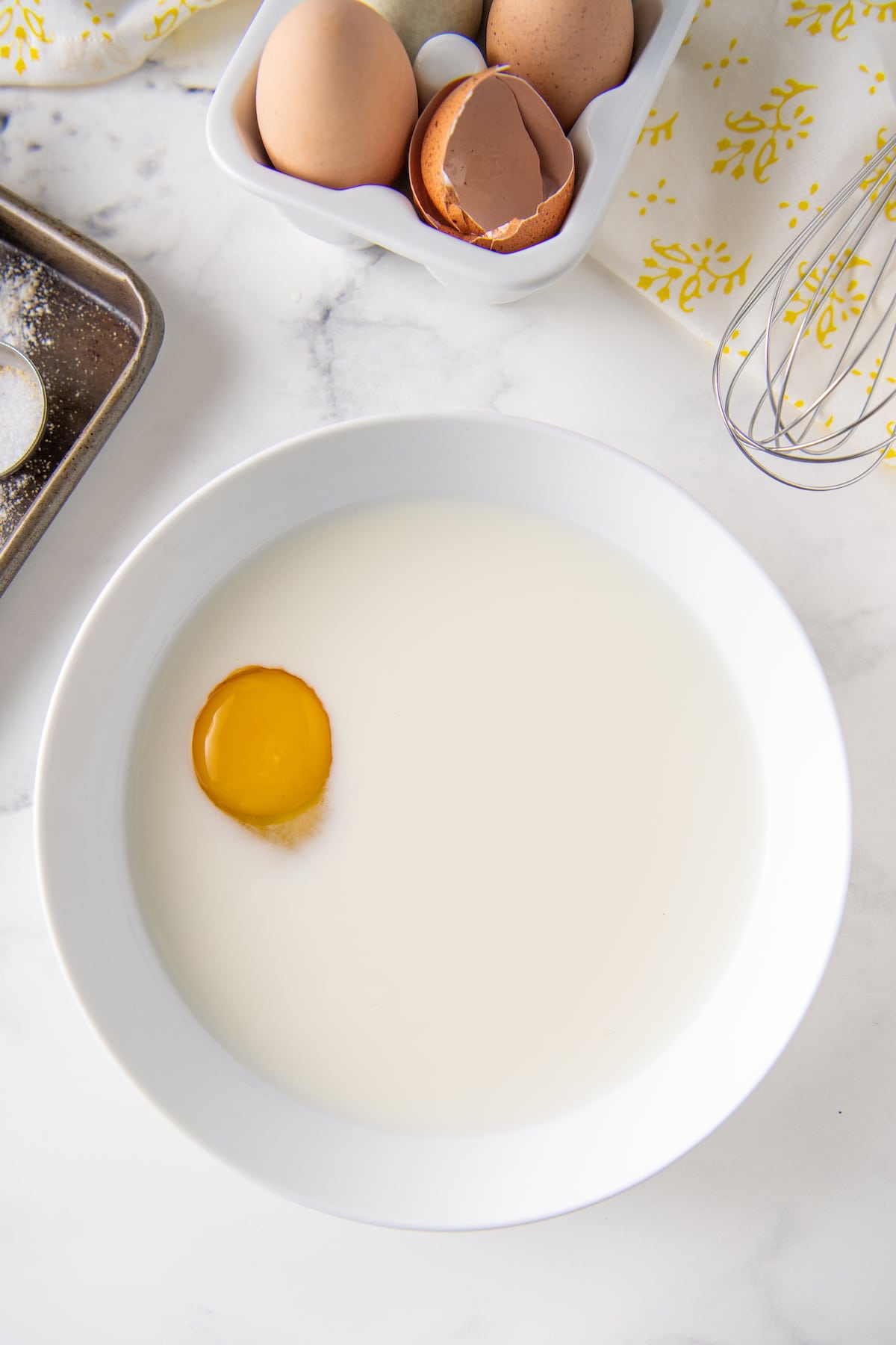 a bowl filled with milk and one egg yolk