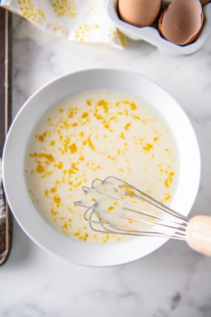 a bowl with egg and milk mixed together