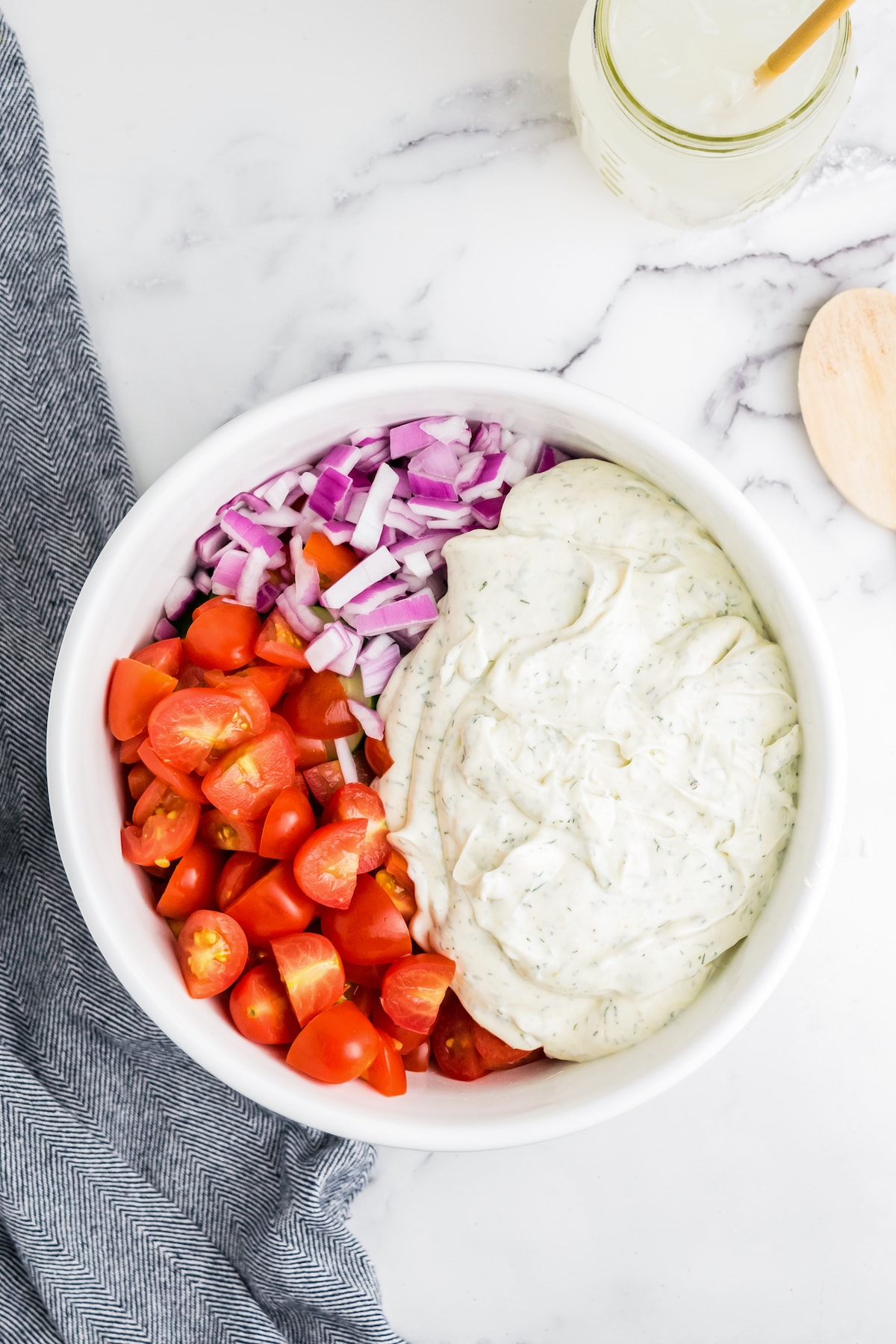 a bowl with chopped tomatoes, red onions, and creamy dressing