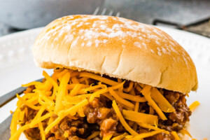 Sloppy Joe sandwich with beef, meat sauce, and shredded cheese