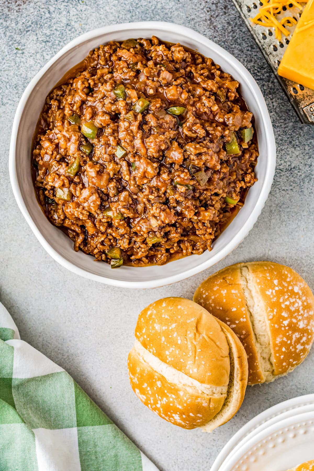 sloppy joe mix in a small casserole dish with two buns next to it
