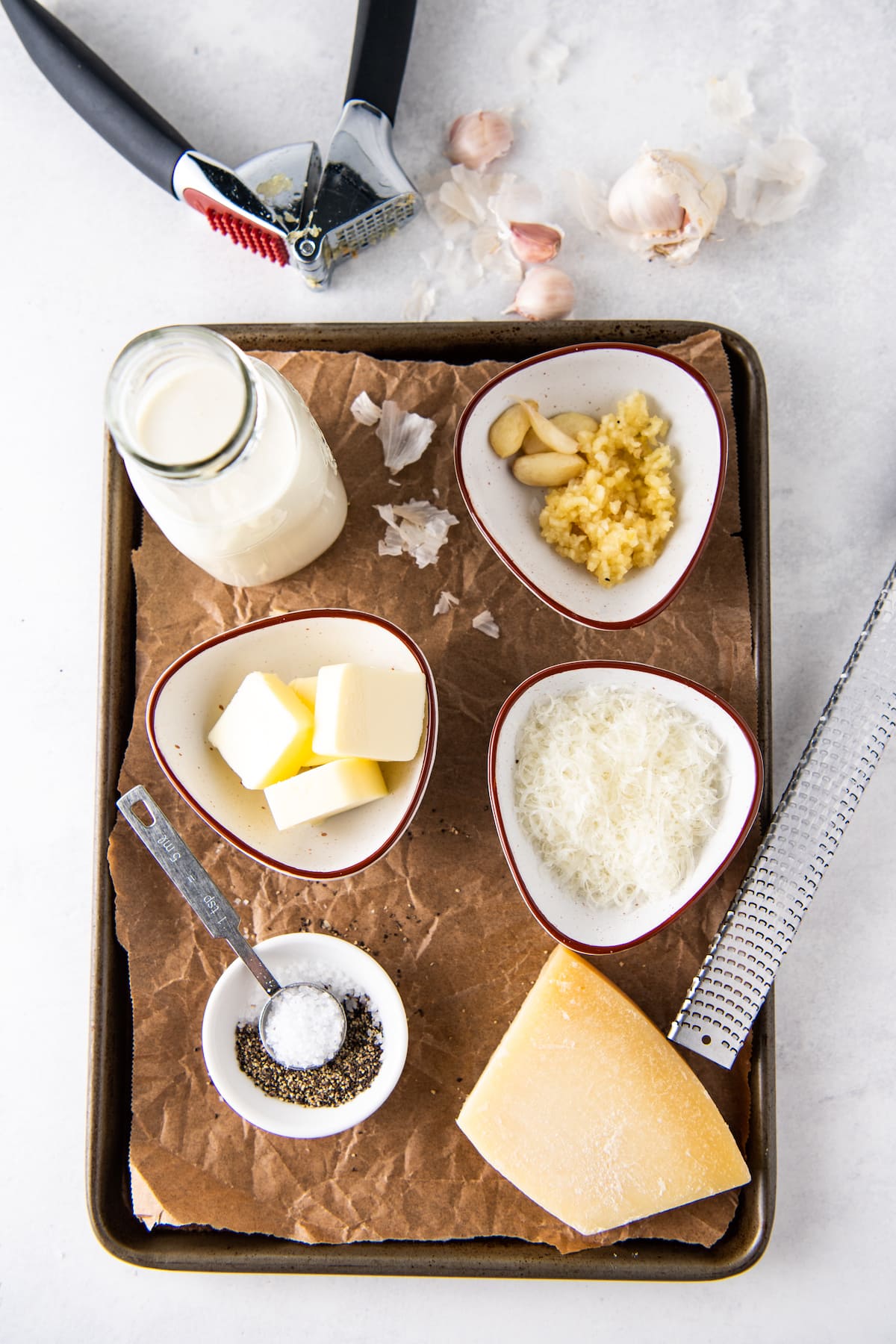 ingredients to make alfredo sauce like butter, parmesan cheese, garlic, cream, salt and pepper