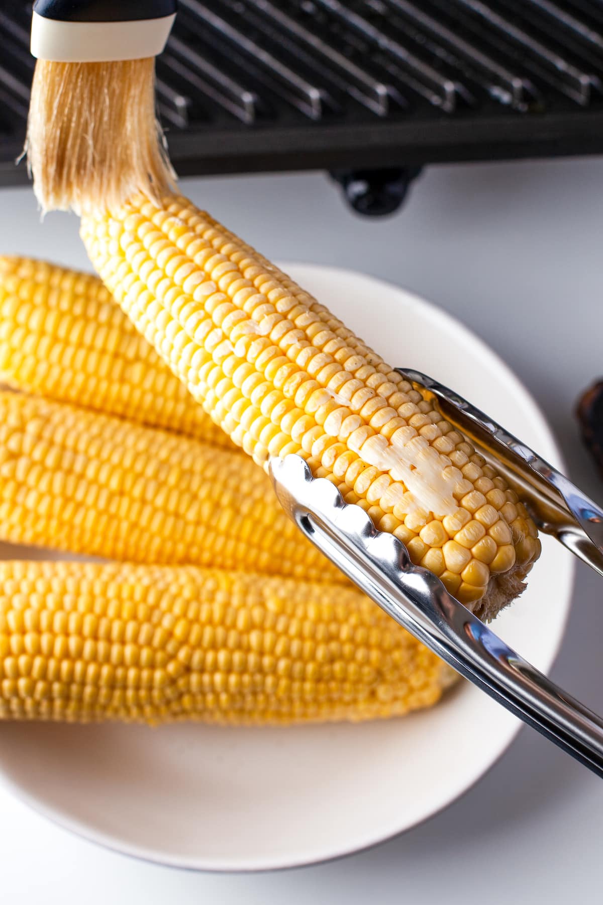 tongs holding corn on the cob