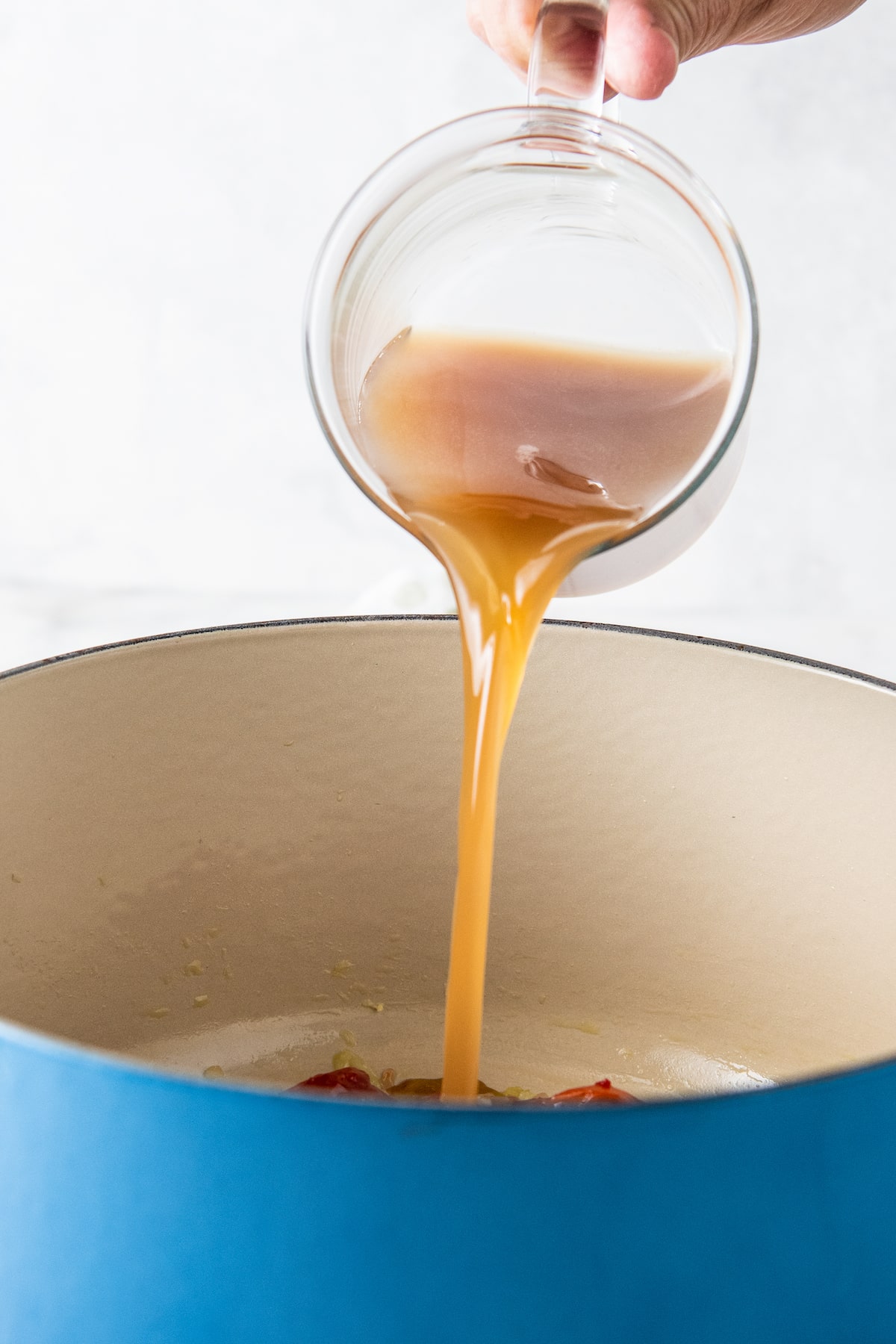 pouring broth into a dutch oven