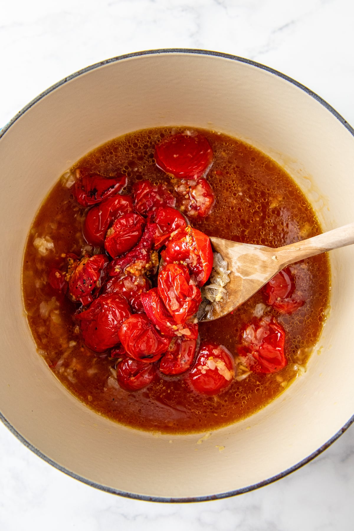 a large pot with roaste tomatoes and other ingredients to make soup