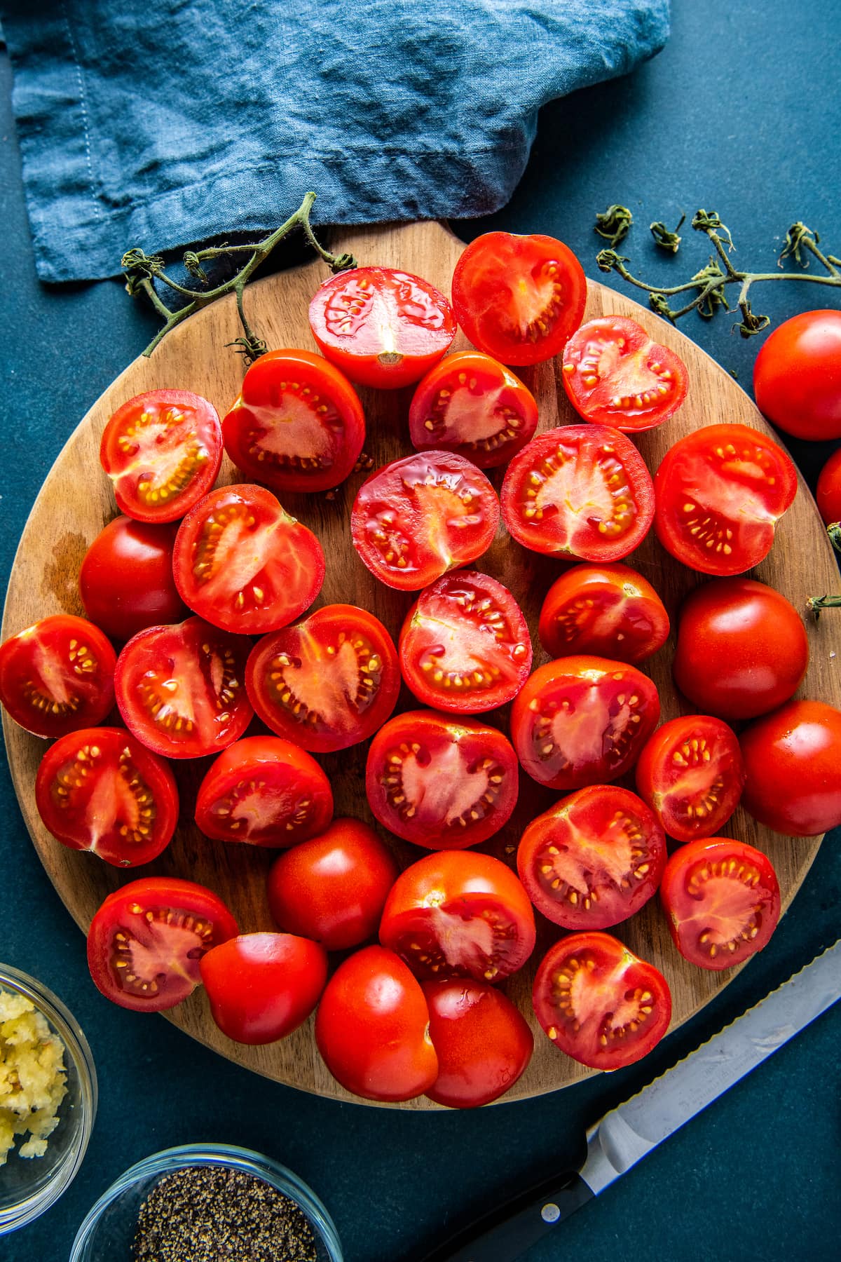 halved tomatoes on a round wooden cutting board