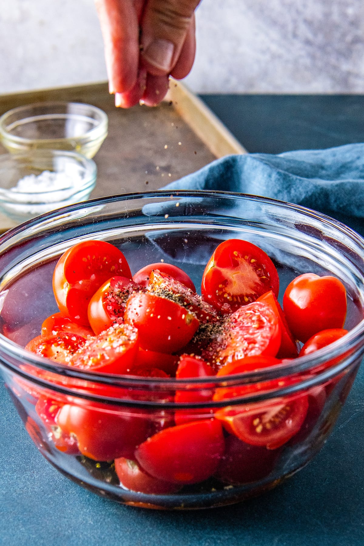 a bowl with cut up tomatoes and seasoning on top