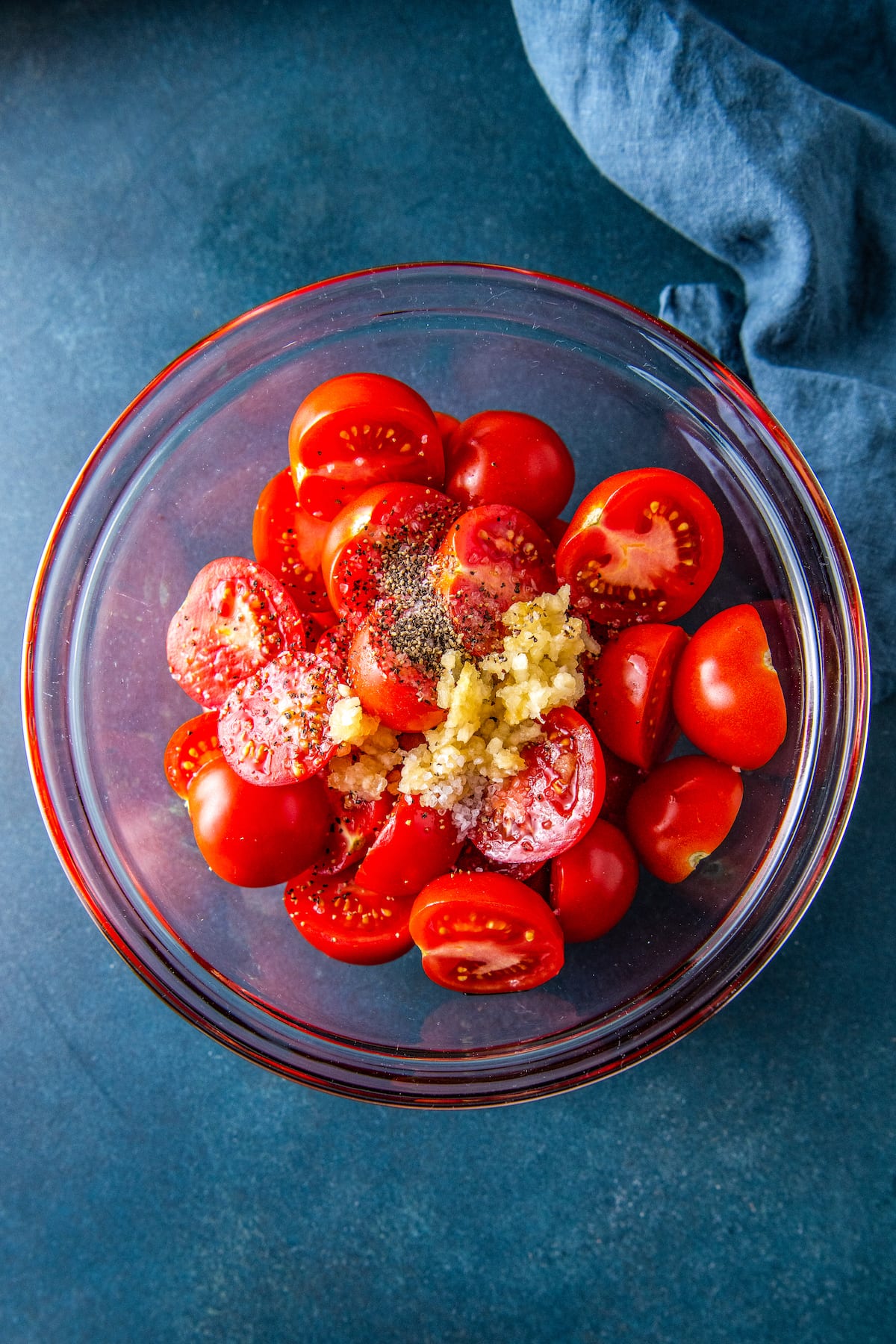 a bowl with cut up tomatoes and seasoning on top
