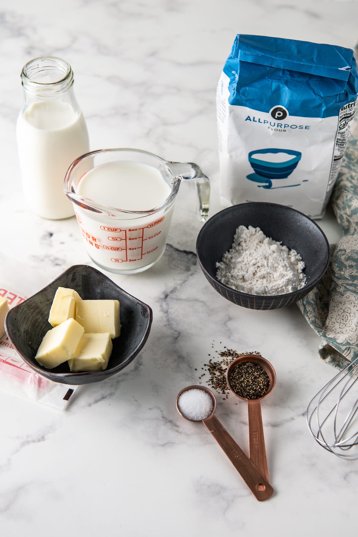 the ingredients to make homemade white gravy such as cream, flour, butter, and seasonings