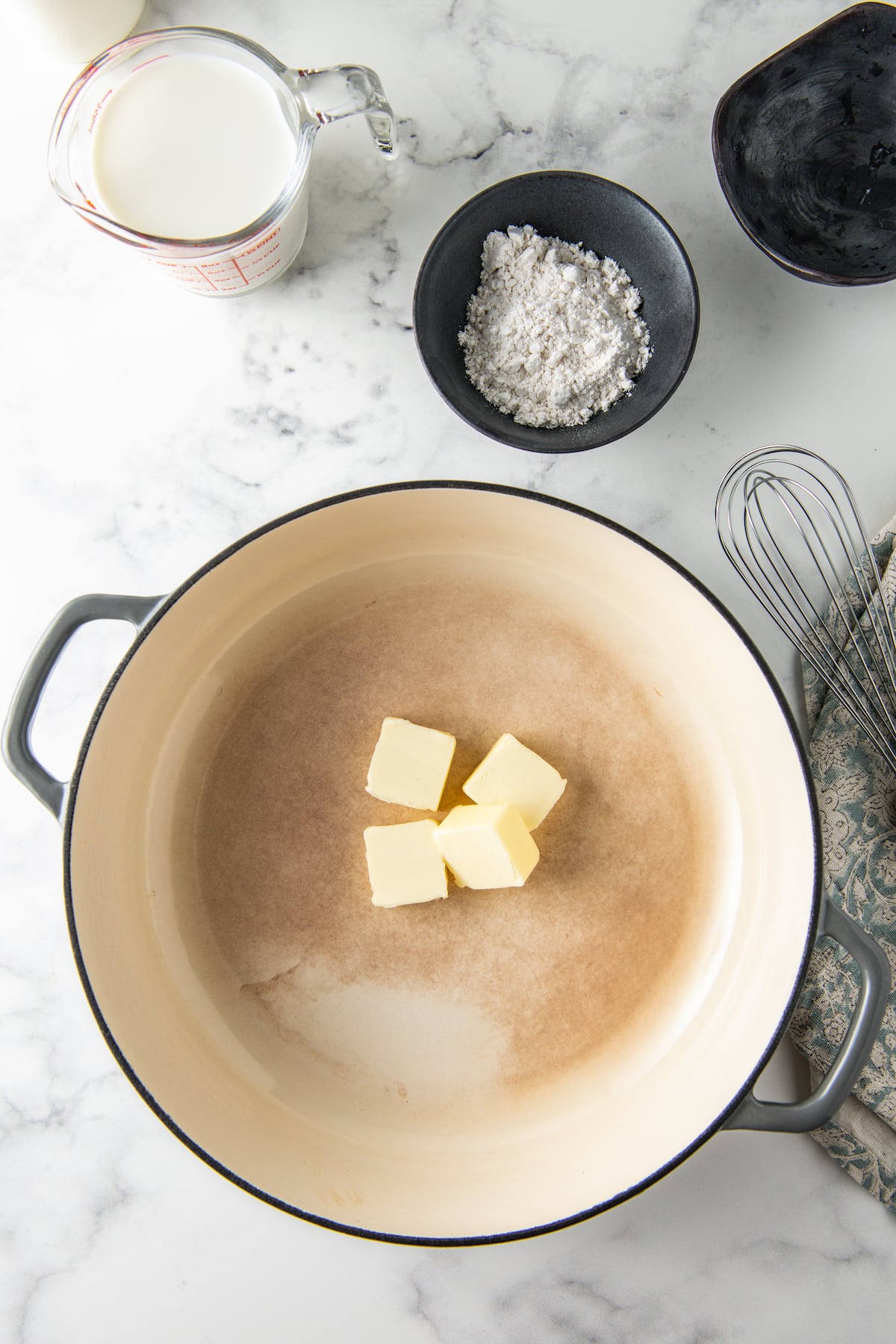 butter in a large pan alongside a bowl with flour and a whisk