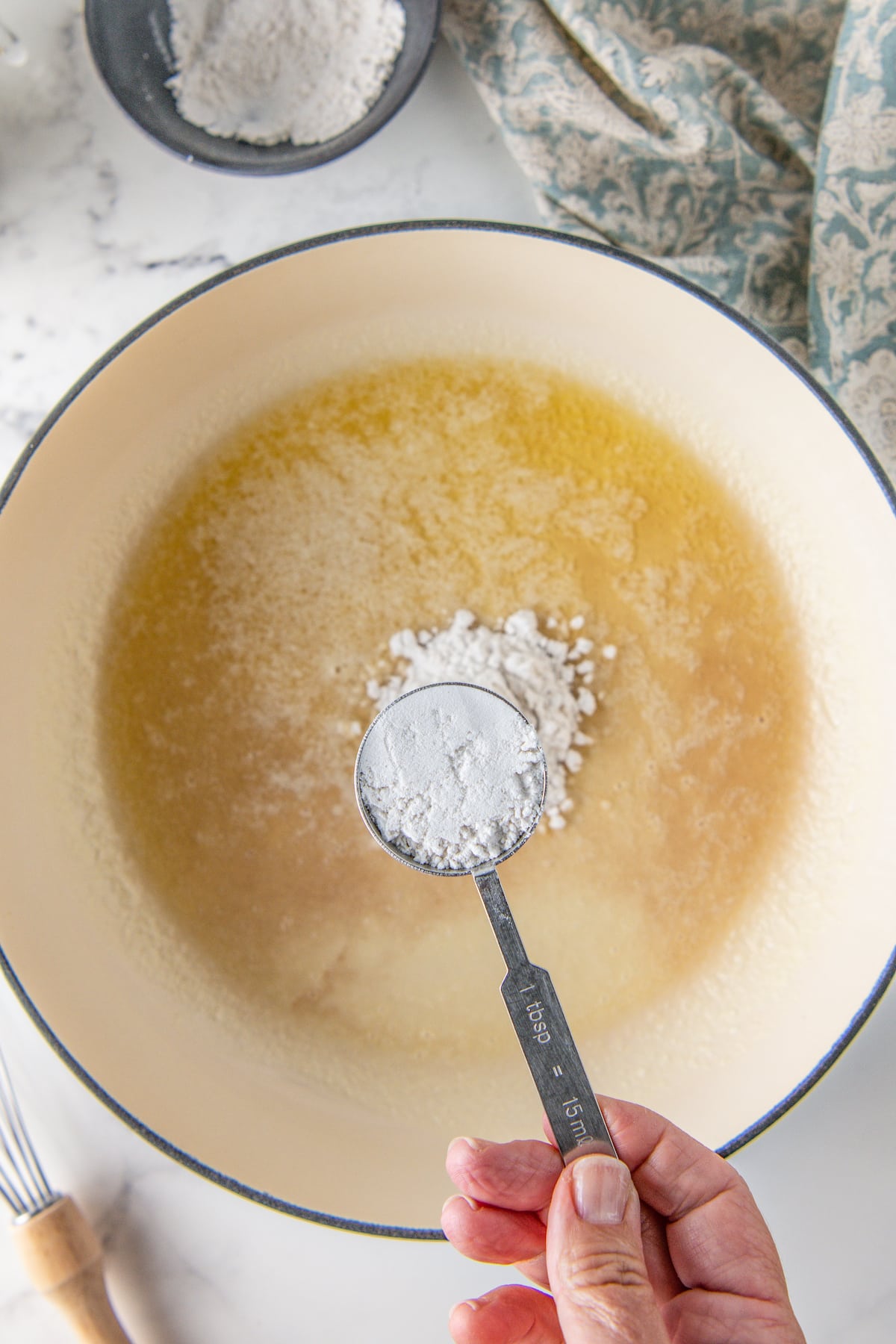sprinkling flour into a pot with melted butter