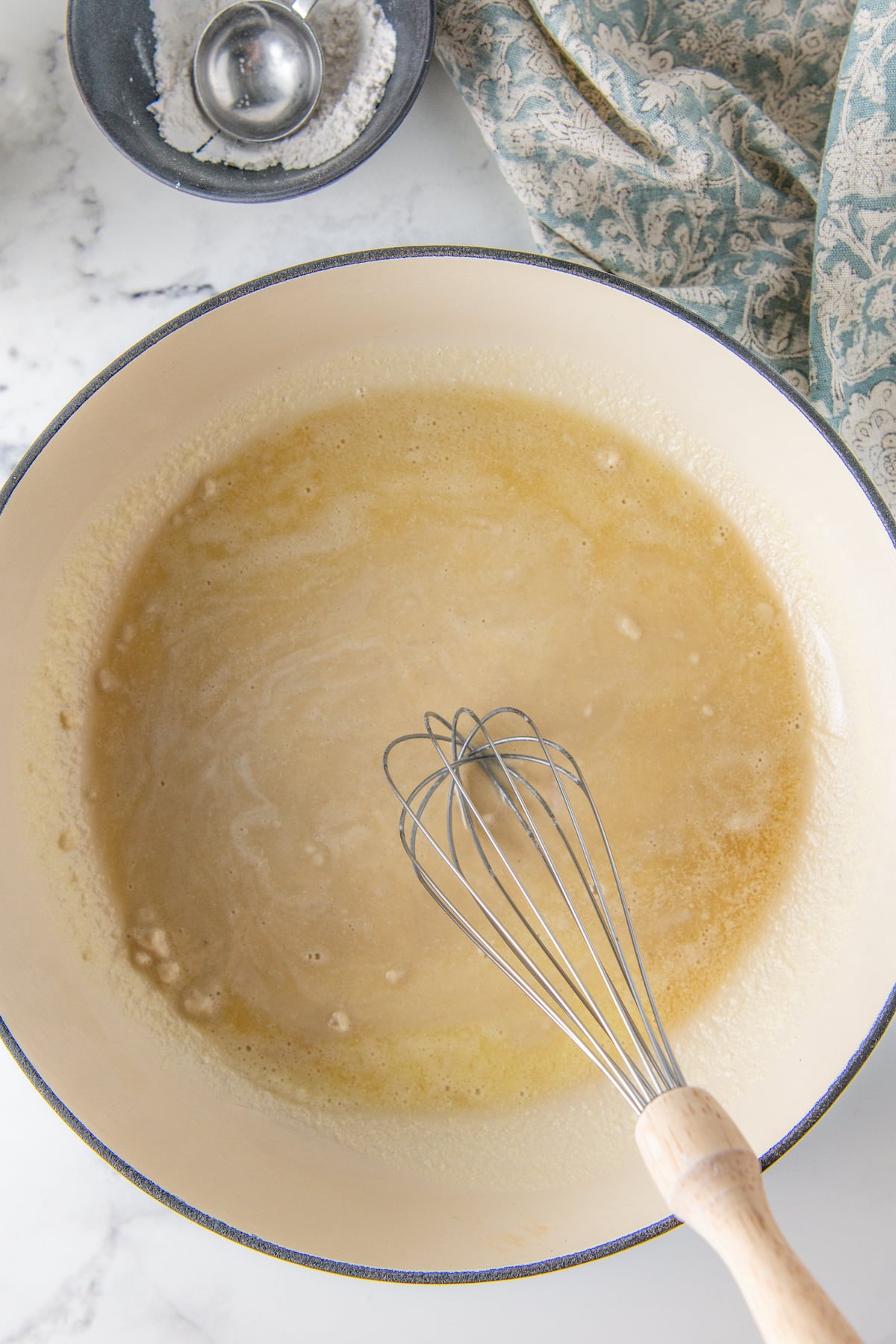 making a roux in a pot, which is a mixture of melted butter and flour