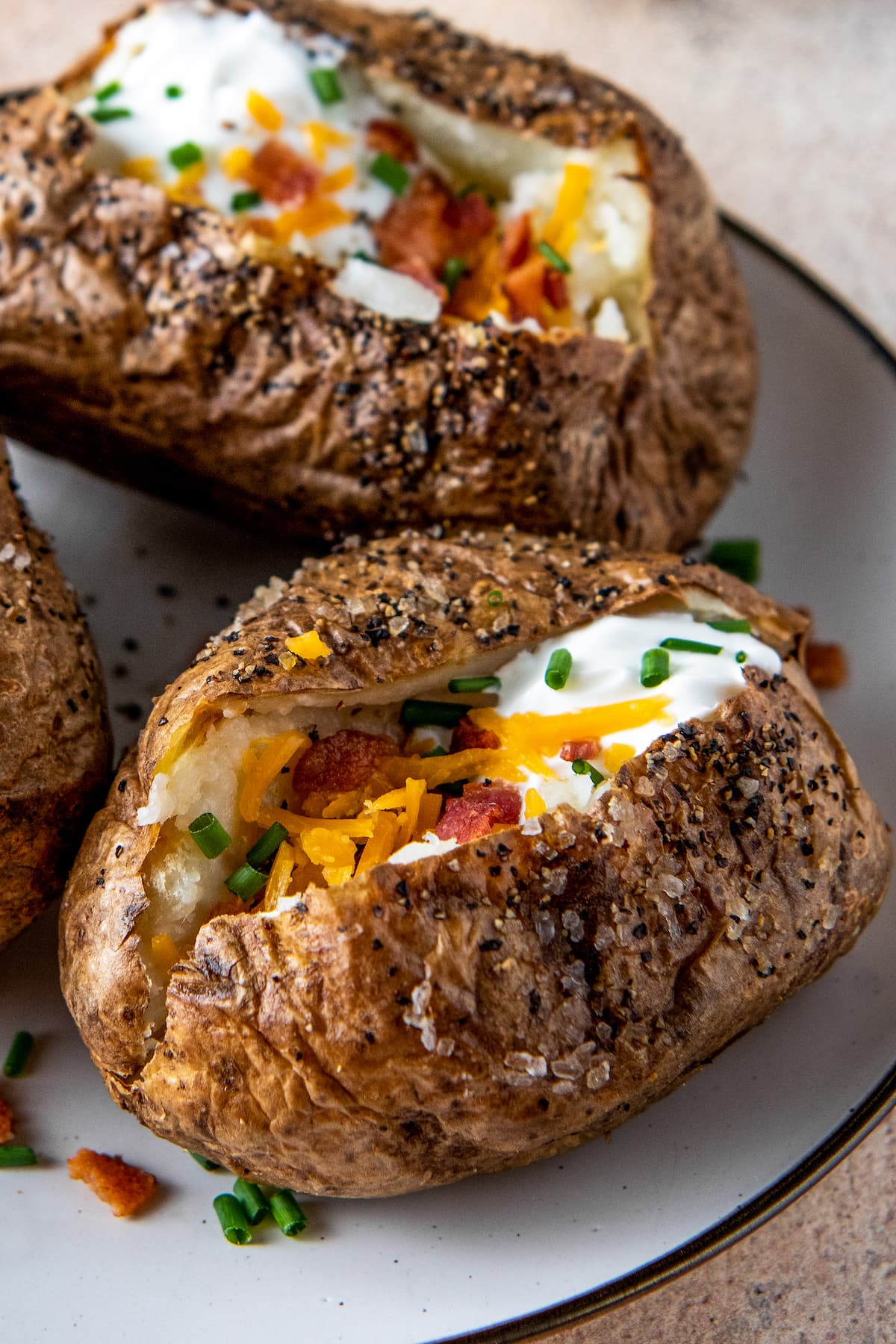 air fryer baked potato with sour cream, bacon, chives and cheese