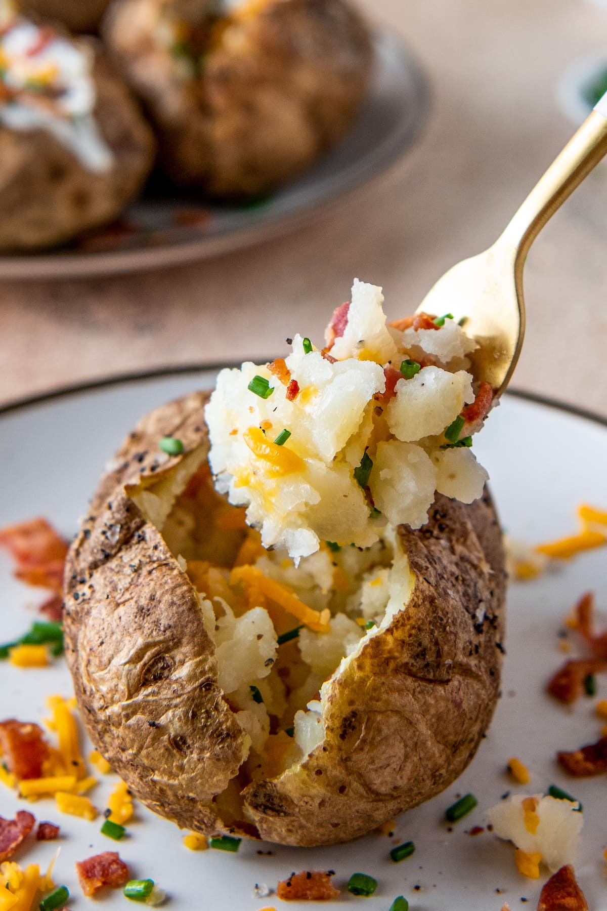 a baked potato with a fork taking a bite out