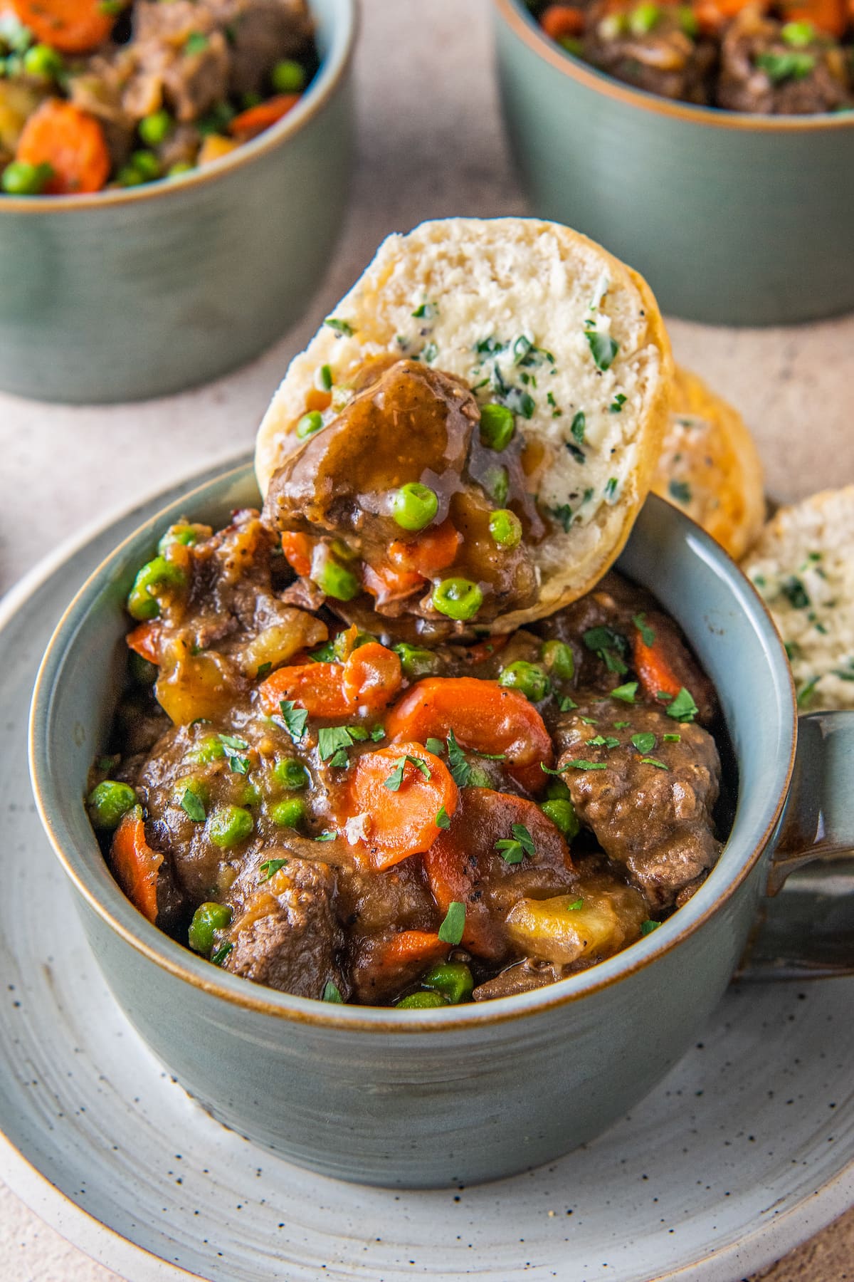 a piece of bread being dipped into beef stew