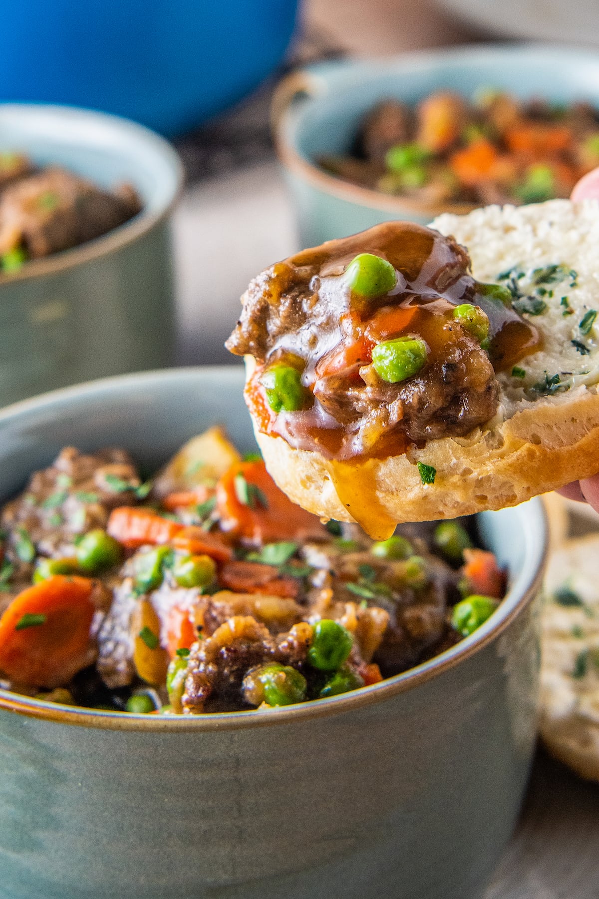 a piece of bread being dipped into beef stew