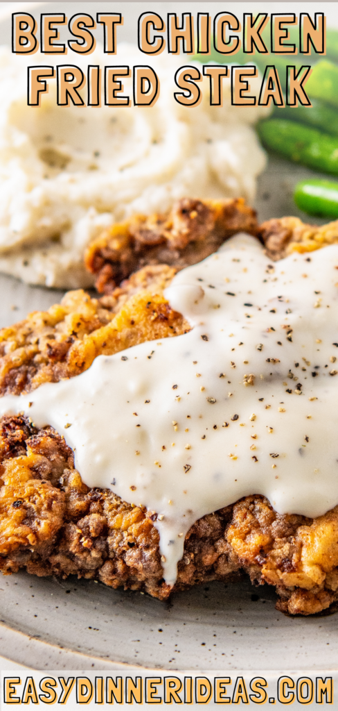 Chicken fried steak on a plate with white gravy on top.