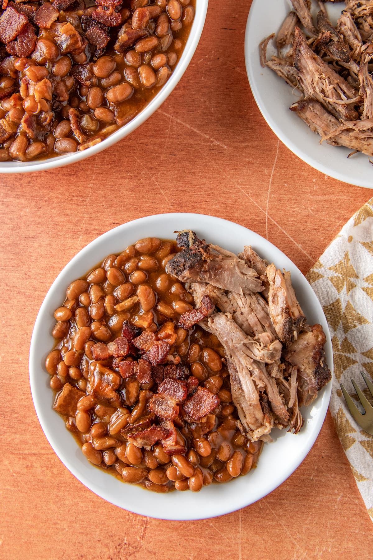 baked beans in a bowl with pulled pork on the side