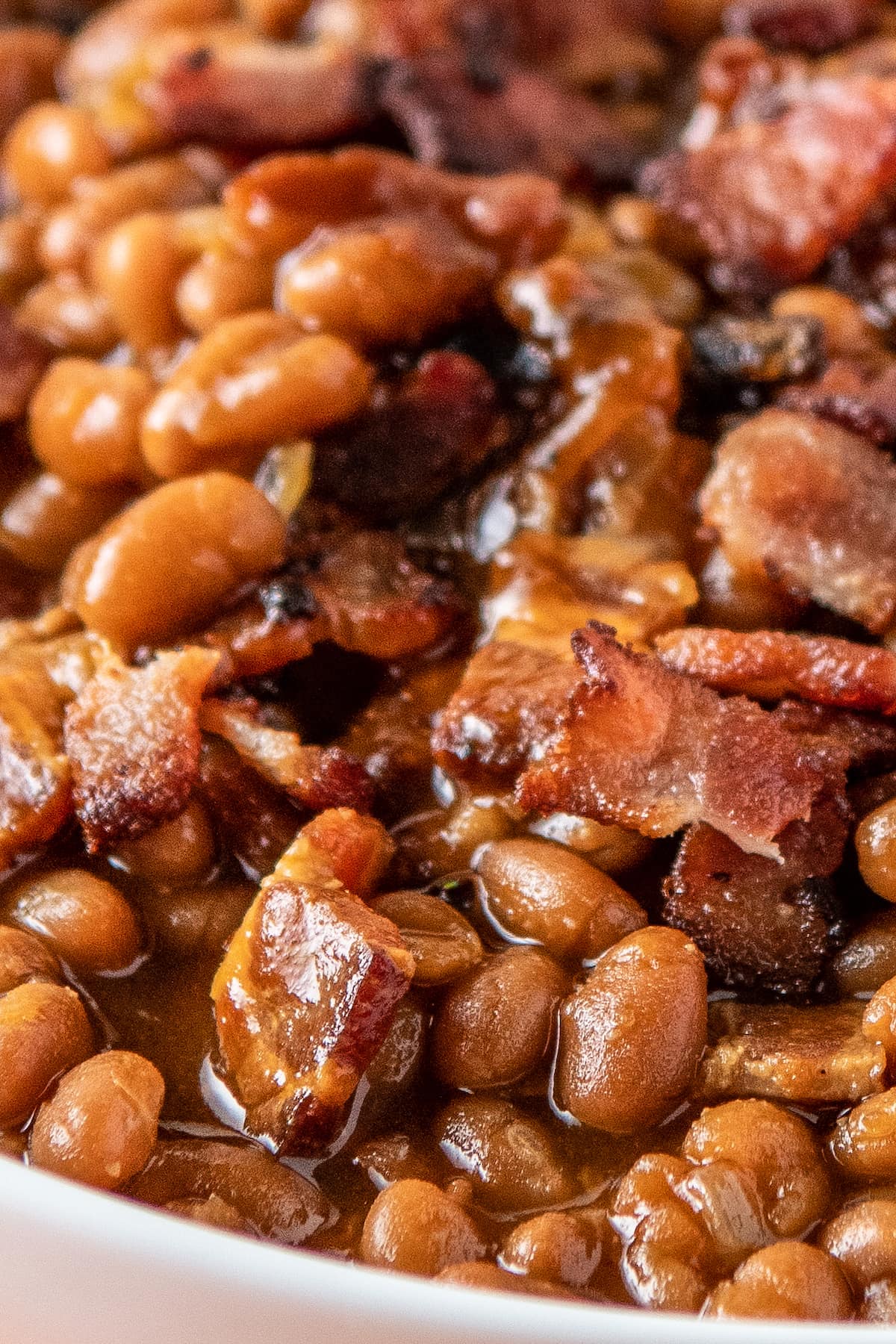close up of baked beans with bacon pieces