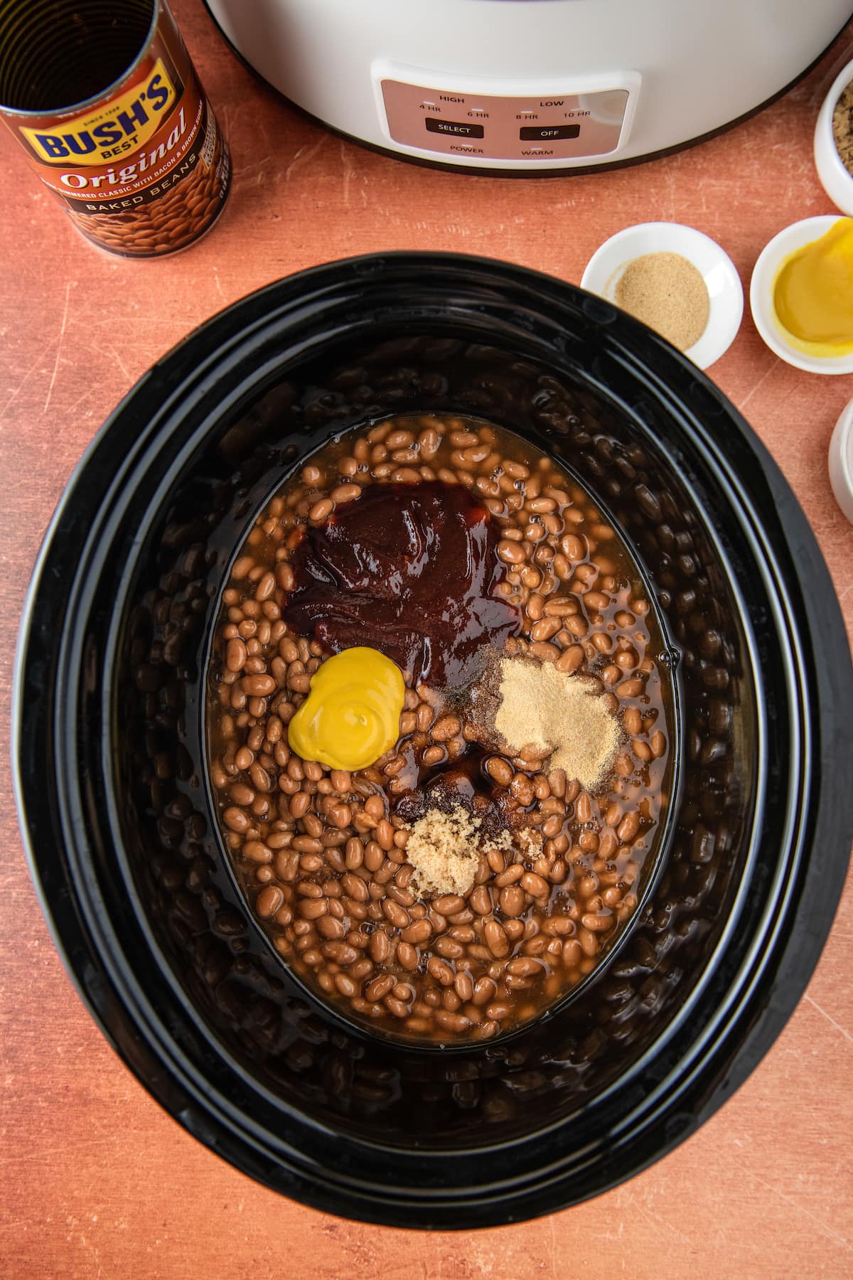 crockpot with beans, mustard, sauce, and other seasonings