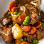 ladling beef stew into a bowl
