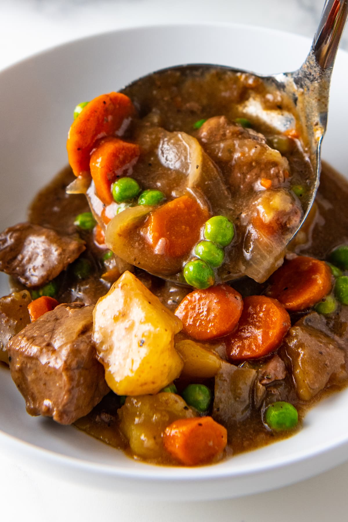 ladling beef stew into a bowl