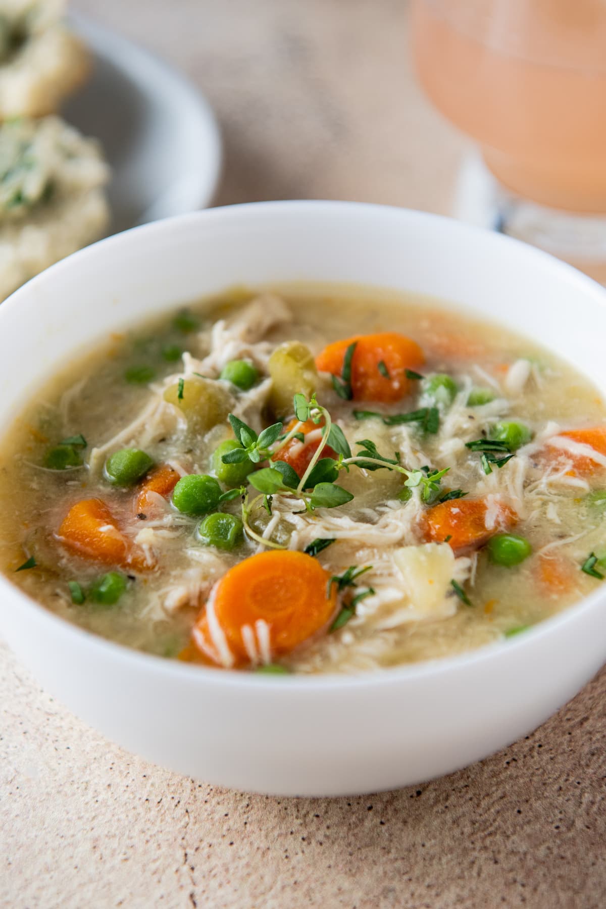 slow cooker chicken stew with carrots and peas in a white bowl