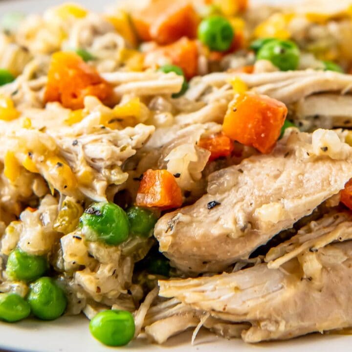 close up of a meal with crockpot chicken and rice that includes vegetables and cheese
